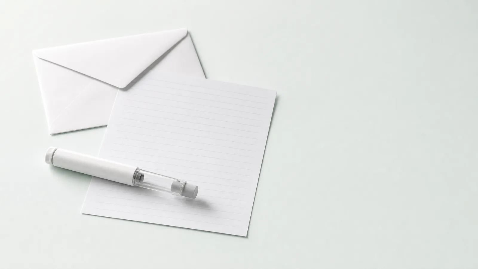 Studio still life: a plain envelope, a blank form and an unbranded pen injector